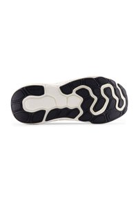 Suela de zapato con una banda de rodadura de goma negra que presenta diversas texturas y contornos, junto con una entresuela de color blanco roto que proporciona contraste y soporte.