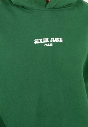 Grüne Kapuzenjacke aus Baumwollstoff mit einer vorderen Tasche, Kordelzugkapuze und einem weißen Aufdruck "SIXTH JUNE PARIS" auf der Brust.
