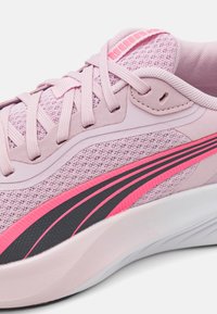 Lyserosa treningsko med en teksturert mesh-overdel, kontrasterende svarte og rosa striper, og en polstret krage for komfort.