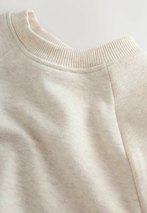 Beige Sweatshirtkragen mit gerippter Textur, aus weichem, leicht meliertem Material und rundem Halsausschnitt. Nähte sind sichtbar.