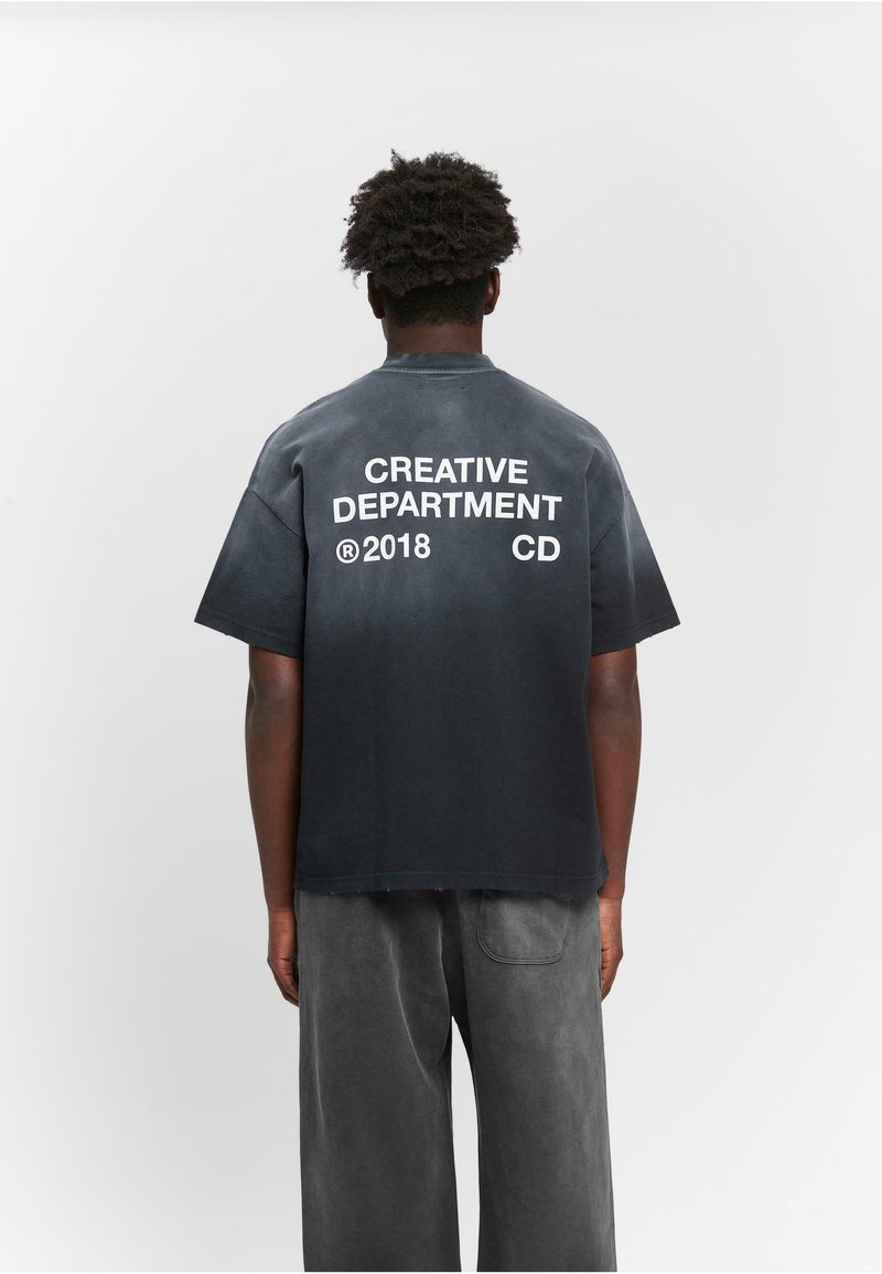 Schwarzes Baumwoll-T-Shirt mit Rundhalsausschnitt und kurzen Ärmeln, das auf der Rückseite auffälligen weißen Text zeigt: "CREATIVE DEPARTMENT", "CD" und "2018".