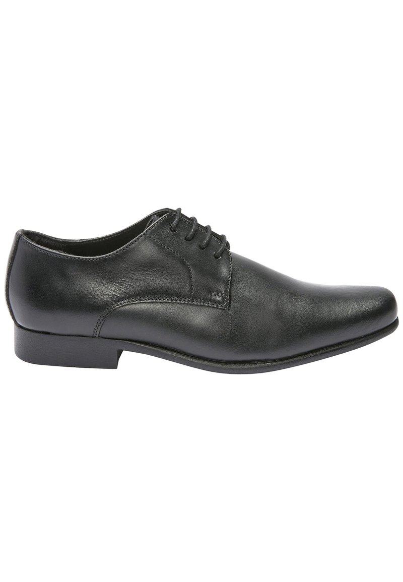 Chaussure habillée en cuir noir avec un bout arrondi, un design à lacets et une texture lisse. Elle possède un talon bas et plat avec des détails de couture simples.