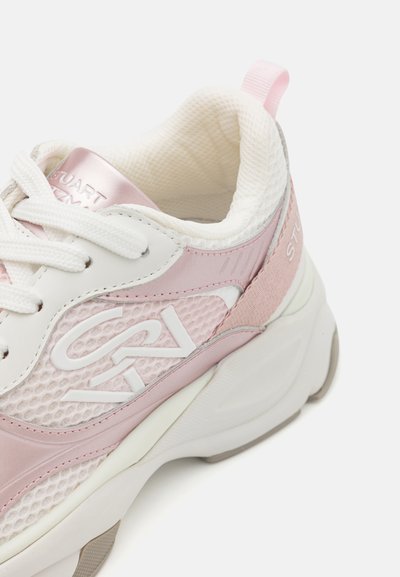 Vaaleanpunaiset sneakersit, joissa on verkko- ja synteettistä nahkaa, valkoisia yksityiskohtia, paksut pohjat ja silmukka kantapäässä helpompaa pukemista varten.