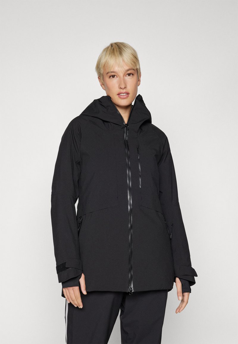 Black waterproof jacket featuring a high collar, adjustable cuffs, front zipper, and dual side pockets for utility and warmth.