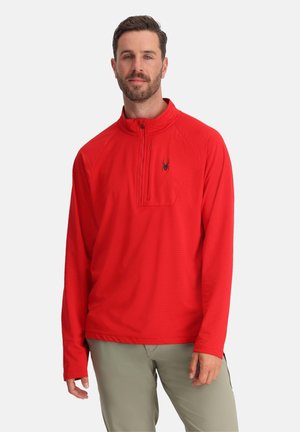 Red quarter-zip pullover with a textured fabric and black spider logo on the chest. Long sleeves and a relaxed fit.