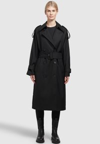 Černý trench coat s dvouřadým designem, širokým límcem, páskem v pase a ramenními epauletami. Hladká tkanina s bočními kapsami.