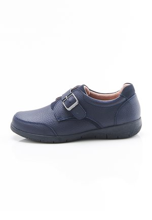 Chaussure en cuir bleu marine avec surface texturée, bride à boucle simple, talon bas et col rembourré pour le confort sur fond blanc.