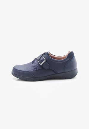 Chaussure en cuir bleu marine avec surface texturée, bride à boucle simple, talon bas et col rembourré pour le confort sur fond blanc.