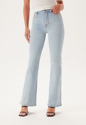Lichtblauwe flared jeans van denim met een hoge taille. Bevat vijf zakken, een knoopsluiting en subtiele vervaging. Draag met zwarte hakken.