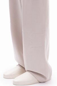 Ανοιχτό γκρι παντελόνι με φαρδιά γραμμή από απαλό ύφασμα με λεία υφή, που διαθέτει δύο διακριτικές τσέπες κατά μήκος της εξωτερικής ραφής.