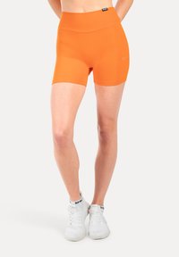 Pantalones cortos deportivos naranjas con una cinturilla alta, confeccionados con un material suave y elástico, diseñados para brindar comodidad y movilidad durante la actividad.