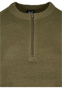 Maslinasto zeleni pleteni pulover s visokim ovratnikom i kratkim zatvaračem. Teksturirana tkanina u rebrastom uzorku. Nema vidljivih dodatnih ukrasa.