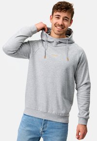 Sudadera gris con capucha ajustable, puños y dobladillo acanalados, que presenta un sutil logo dorado en el pecho. Tejido suave y texturizado.