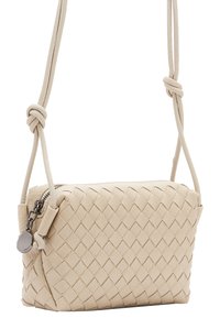 Borsa a tracolla in pelle intrecciata beige con chiusura a zip, dotata di una tracolla annodata e un accento hardware laterale. Texture liscia e forma compatta.