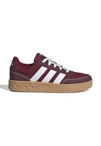 Baskets Adidas bordeaux avec des rayures blanches, des lacets blancs et une semelle marron clair embossée du logo "adidas", vue de côté sur fond blanc.