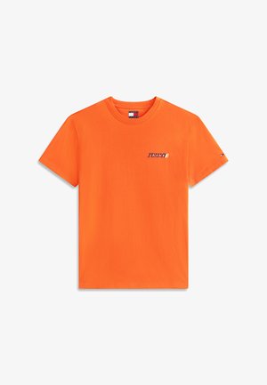 Svetlo orančna kratka majica s kratkimi rokavi z majhnim napisom "Tommy" na levi prsni strani in oznako Tommy Jeans znotraj ovratnika.