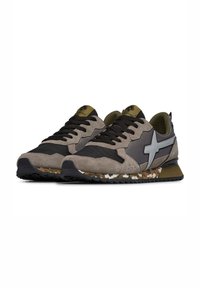 Zapatillas de hombre con parte superior de ante marrón y malla negra, acentos grises, suela con patrón de camuflaje y cordones negros.