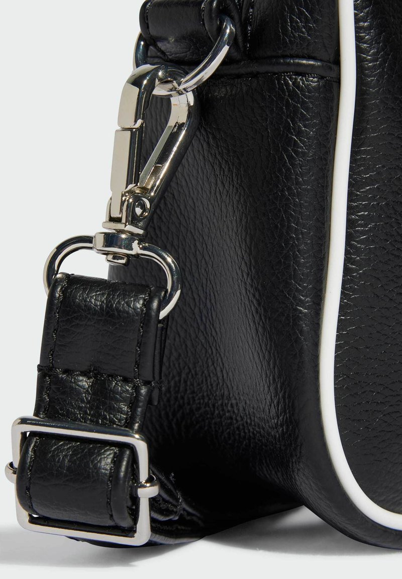 Schwarze Ledertasche mit strukturiertem Finish, ausgestattet mit einem silbernen Metallclip und einem Schnallenriemen, akzentuiert durch einen weißen Paspelrand.