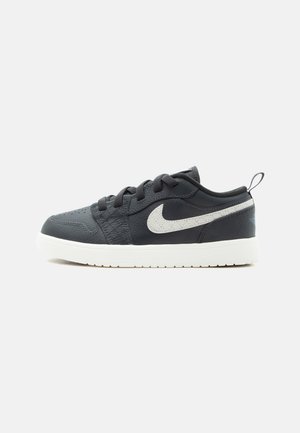 Μαύρο sneaker χαμηλού προφίλ με λευκή σόλα και λευκό λογότυπο Nike swoosh στο πλάι, με μαύρα κορδόνια και ταινία τραβήγματος στη φτέρνα.