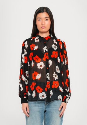 Blouse noire transparente avec un motif floral comportant des fleurs rouges, blanches et jaunes. Manches longues, col, fermeture à boutons sur le devant.