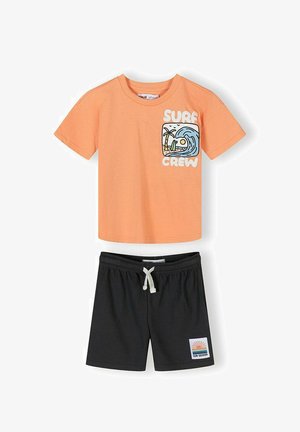 Orange kortærmet skjorte med "Surf Crew" og bølgemotiv, kombineret med sorte shorts med snøre og en "Sun Seeker" mærkat.