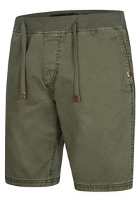Shorts vert olive avec un cordon de serrage à la taille, fabriqués en tissu léger, dotés de poches latérales et d'un petit logo à l'avant.