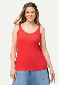 Top rosso senza maniche con spalline sottili e scollatura a V. Realizzato in tessuto a coste, presenta una silhouette aderente e una texture liscia.