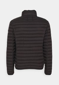 Svart vadderad pufferjacka med ståkrage och dragkedja. Har horisontell sömnad och elastiska ärmslut. Minimalistisk design.