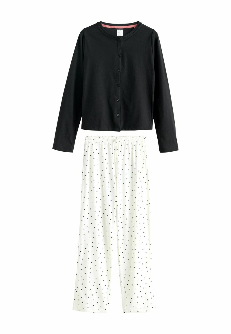 Black long-sleeve buttoned top paired with white wide-leg pants featuring a black polka dot pattern and elastic waistband.