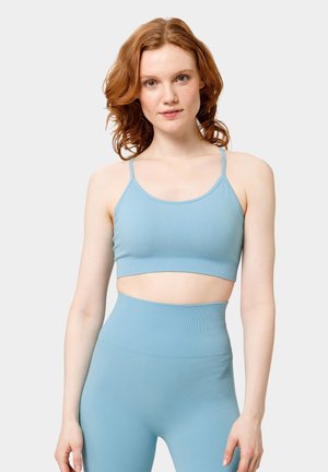 Top corto acanalado de color azul claro con tirantes finos, diseño que deja al descubierto el abdomen, combinado con leggings de cintura alta a juego. Textura suave.