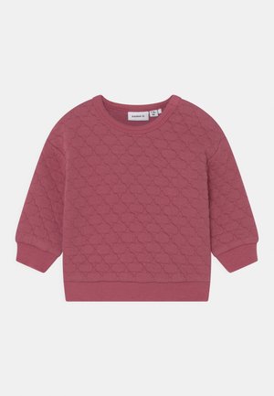 Sweat-shirt matelassé rose avec un col rond et des poignets côtelés. Présente un motif texturé et une étiquette à l'intérieur du col.