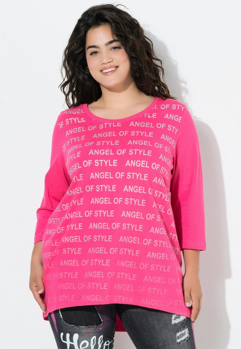 Top fucsia a maniche lunghe con stampa "ANGEL OF STYLE" in argento, abbinato a jeans scuri strappati. Tessuto morbido e vestibilità comoda.