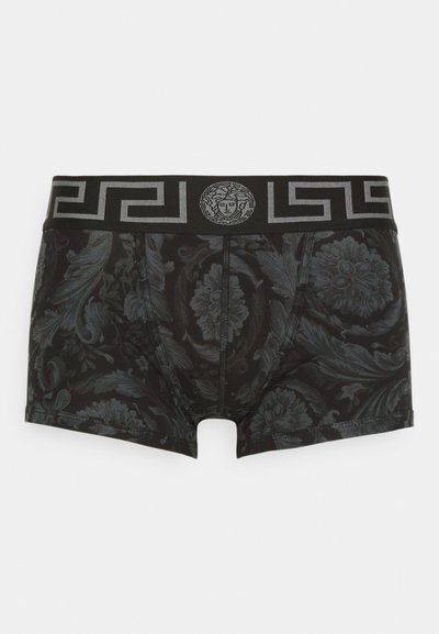 Μαύρα μποξεράκια με λουλουδάτο σχέδιο, ελαστική ζώνη μέσης με σχέδιο ασημένιου ελληνικού κλειδιού και λογότυπο Μέδουσας στο κέντρο μπροστά.