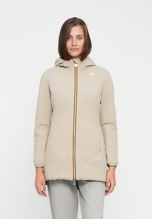 Lichtbeige jas met een capuchon, voorzien van een meerkleurige rits en elastische manchetten. Twee zijzakken en een klein logo op de borst.