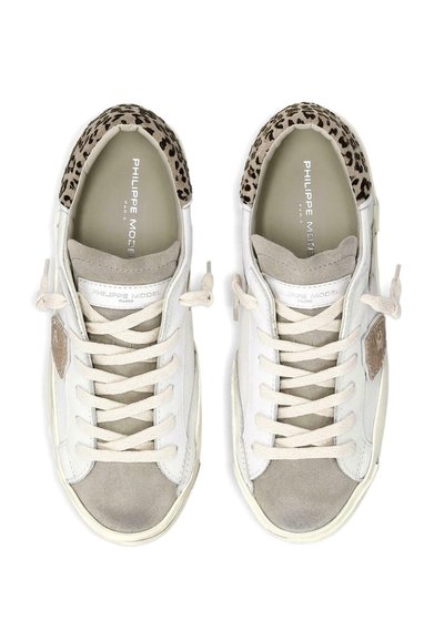 Zapatillas blancas y grises con detalle de estampado de leopardo en el talón, cordones atados en un lazo y la marca "Philippe Model Paris" en el interior.