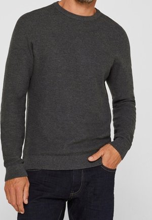 Pull noir en col ras du cou fabriqué dans un tissu doux. Il présente des poignets et un ourlet côtelés, avec une texture lisse et une coupe classique.