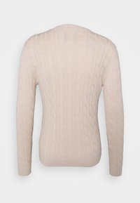 Beige kabelstickad tröja med långa ärmar, rundad halsringning och ribbad nederkant. Har ett texturerat mönster längs kroppen och ärmarna.