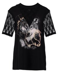 Svart T-shirt med en grafisk bild av en varg, spetskortärmar och en V-ringning. Har en cirkulär design och text under bilden.