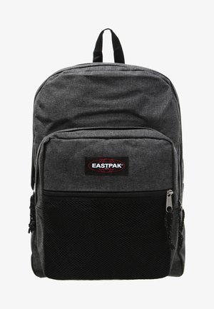 Sac à dos en tissu gris avec une texture lisse, comprenant une poche en maille à l'avant, des fermetures éclair et un patch logo. Deux bretelles ajustables.