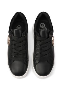 Sneaker in pelle nera con punta tonda, suola piatta bianca e lacci neri coordinati. Presenta un accento decorativo dorato sul lato.