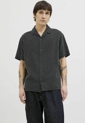 Zwart knoopshirt met korte mouwen en een wit kruispatroon. Gemaakt van lichtgewicht stof, met een kraag en een relaxte pasvorm.