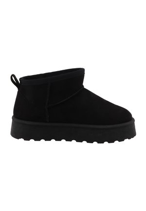 Stivale nero in suede con suola spessa in gomma e linguetta sul tallone, visto dal lato esterno.