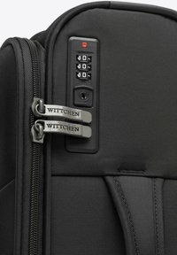 Černý kufr na kolečkách s texturovaným textilním povrchem, dvojicí kovových zipů s gravírováním "Wittchen" a panelem s kombinovaným zámkem.