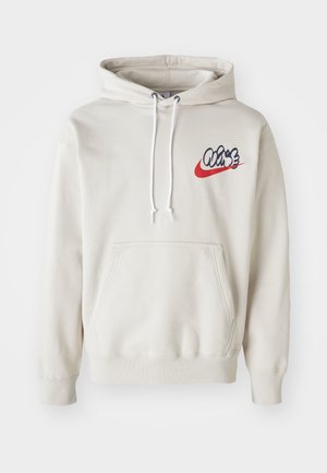 Cream-colored hoodie featuring a front pocket and white drawstrings, with a stylized "Air" logo in blue and red on the chest.