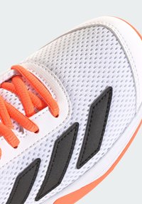 Hvid sportssko med orange snørebånd, sorte detaljer og et netmønster. Har en rundet tå og en polstret sål.