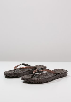 Chanclas marrones con suelas texturizadas y trenzadas. Las tiras son de color marrón oscuro con un acento brillante en bronce en la parte superior.