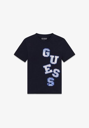Schwarzes kurzärmeliges T-Shirt mit großen blauen und weißen Buchstaben, die vertikal auf einer Seite "GUESS" buchstabieren.