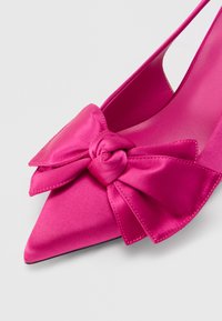 Satynowy, fuksjowy but na wysokim obcasie z ostrym noskiem i dużą kokardą z przodu. Gładka faktura i konstrukcja typu slingback.