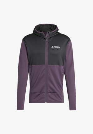 Kapsičková športová bunda s kapucňou v čiernej a tmavofialovej farbe. Má zips vpredu, sieťovanú textúru na hornej časti a bočné vrecká. Ľahký materiál.