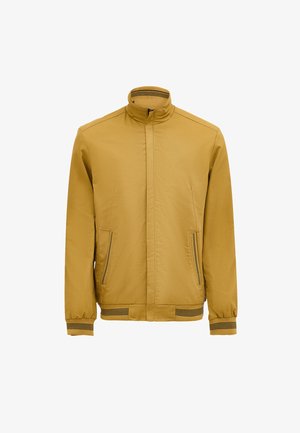 Mustard yellow jacket with a high collar, two zippered front pockets, elastic cuffs, and a plain texture. Horizontal stripe accents on cuffs.